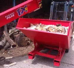 Tipping skip filled with logs