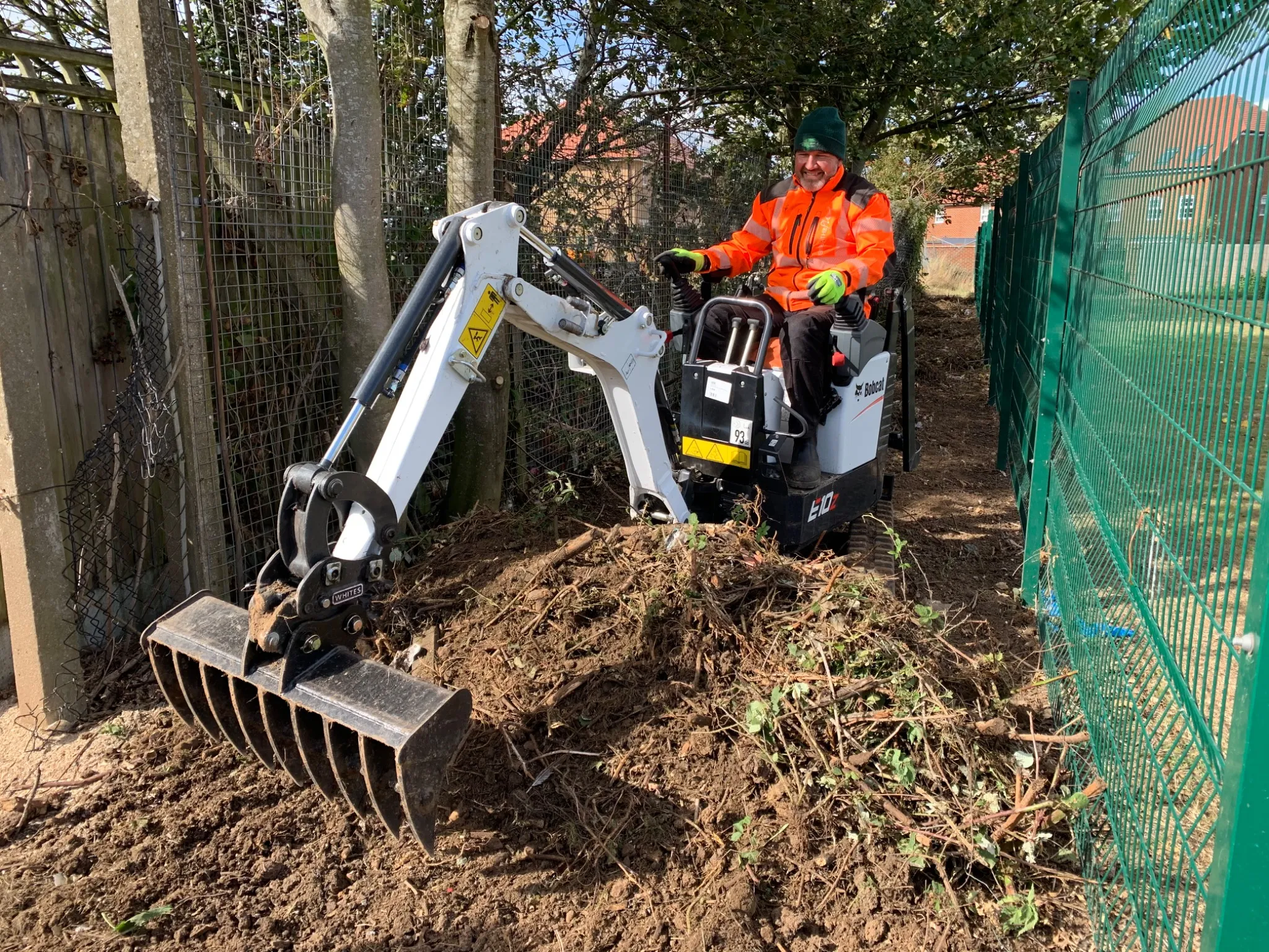 Bobcat E10z using an excavator rake for vegetation clearance